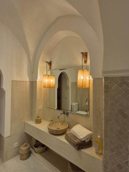 Salle de bains luxueuse de la SUITE HANA au Riad Casa Angelo, Marrakech, avec plafond voûté, vasque ronde et luminaires suspendus