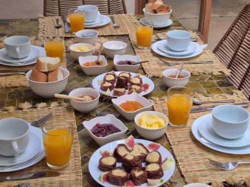 Breakfast spread at Riad Casa Angelo with pastries, fresh juice, fruit, and traditional Moroccan dishes.