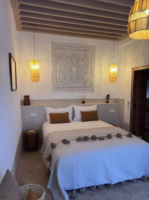 Chambre Hana Suite au Riad Casa Angelo à Marrakech, avec un lit aux coussins décorés, luminaires suspendus et murs ornés