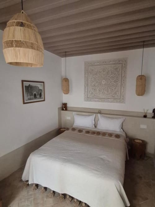 Chambre de la Suite Hana au Riad Casa Angelo à Marrakech, avec luminaires suspendus tressés et décoration murale traditionnelle
