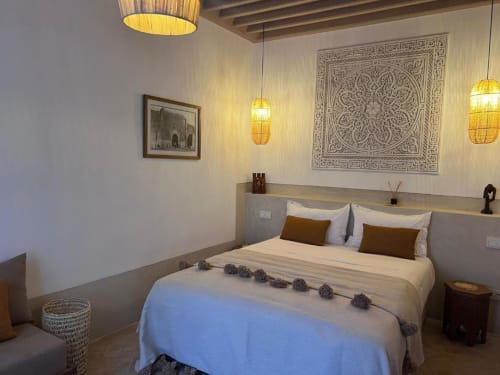 Chambre Hana Suite au Riad Casa Angelo à Marrakech, décorée traditionnellement avec des ornements muraux raffinés et un éclairage doré aux lanternes