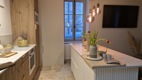 Modern keuken-eetkamer in Clos de Nuits appartement bij Moulin Renaudiots, Autun, met houten kasten en stadsuitzicht