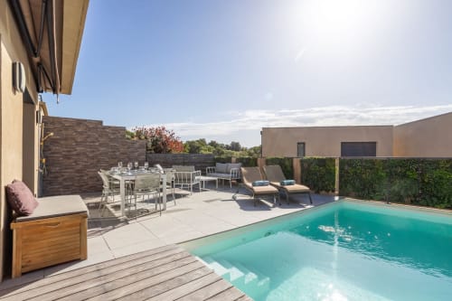 Villa Oia in Favone features a heated pool with loungers, dining area, and modern terrace, managed by Corsu di Core conciergerie