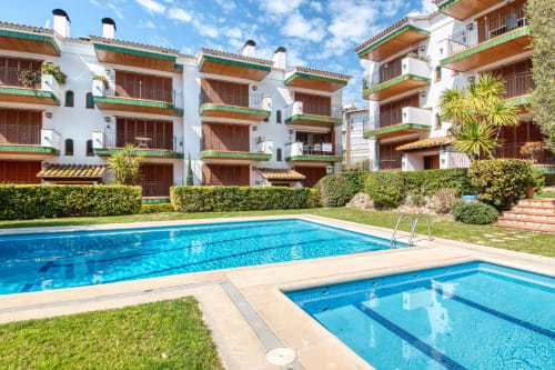 Piscina compartida i banyera d'hidromassatge al complex Ap. Ancora a Palafrugell amb edificis blancs i balcons verds
