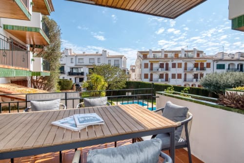 Terrassa ampla a Ap. Ancora a Palafrugell amb taula de fusta, seients còmodes, vistes a la piscina i