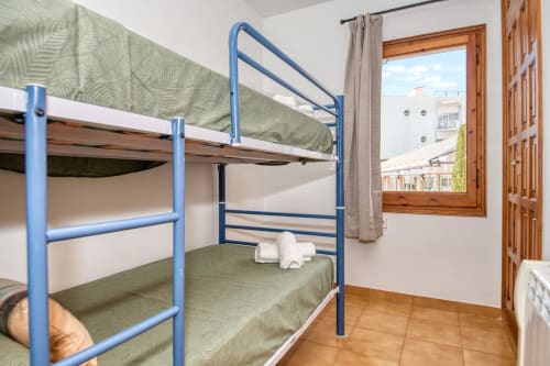 Lits superposats blaus amb roba de llit verda al dormitori de l'apartament a Finques Garcia Enrich, Palafrugell