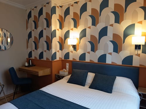 Modern double room at Le Pavillon Saint Martin Hotel in Souillac with geometric patterned wallpaper, desk, and blue accents