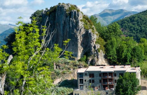 Hotel Flor de Neu with dramatic rocky peak backdrop in El Pont de Suert, nestled in Pyrenees mountains
