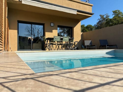 Villa Lagon Bleu pool terrace with heated swimming pool, lounge chairs, and modern accommodations in Favone, Corsica, managed by Corsu di Core conciergerie
