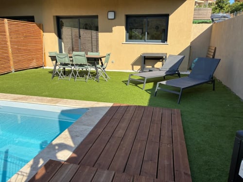 Villa Lagon Bleu pool area with wooden deck, loungers, dining furniture, and manicured lawn, managed by Corsu di Core conciergerie