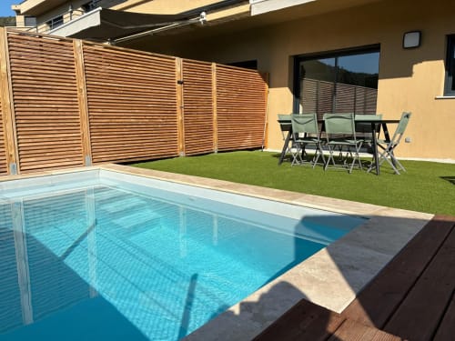 Villa Lagon Bleu heated pool with wooden privacy fence, lounge chairs, and patio, managed by Corsu di Core conciergerie