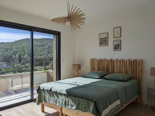 Modern bedroom in Villa Ô Bord de Mer at Favone, with green bedding, wooden headboard, balcony overlooking, managed by Corsu di Core