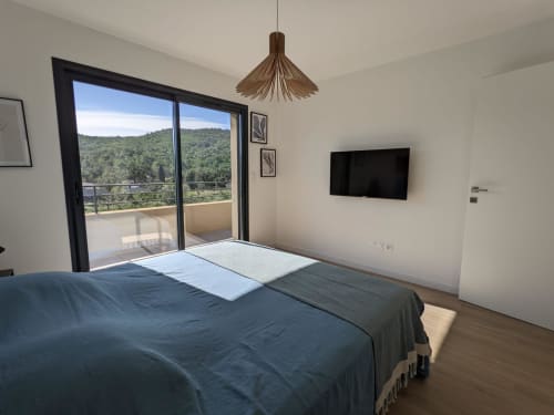 Modern bedroom with mountain views in O Bord de Mer villa, Favone, featuring terrace doors, flat-screen TV, and wooden, managed by Corsu di Core