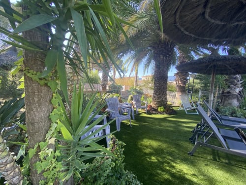 Petit coin détente côté piscine, Pelouse synthétique, arboré, fleuri, transats, parasol. Coin détente idéal pour profiter de ses vacances Argeles sur Mer