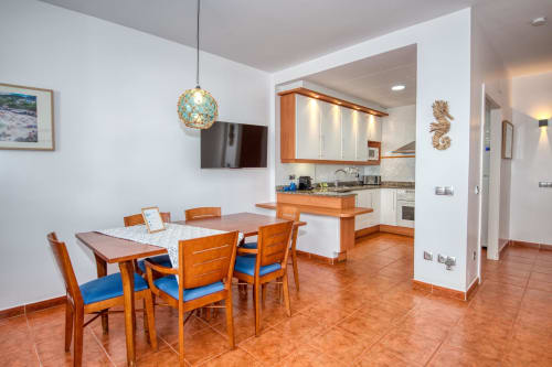 Modern dining and kitchen area in Brisa de Calella apartment, Palafrugell with wooden furniture and terracotta flooring