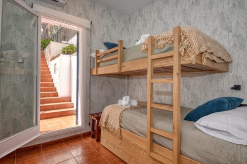 Cozy bunk bed room at Finques Garcia Enrich in Palafrugell with wooden beds, garden view door, and neutral decor