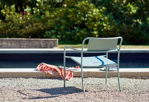 Moderne aluminium stoel bij het zwembad van hotel Moulin Renaudiots in Autun, Frankrijk met handdoek en water