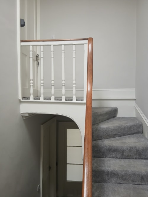 Staircase with wooden handrail and grey carpet leading to Super King room at Eglinton Road Bray hotel