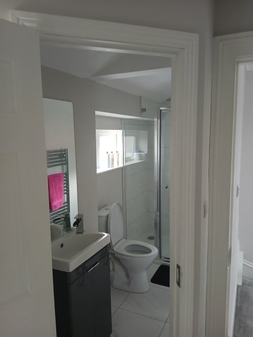 Modern ensuite bathroom at Eglinton Road Bray with white sink, toilet, walk-in shower and heated towel rail