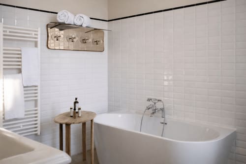 Modern bathroom in Chambre Supérieure at Mas De Lafeuillade, Montpellier with white tile walls, freestanding tub, heated