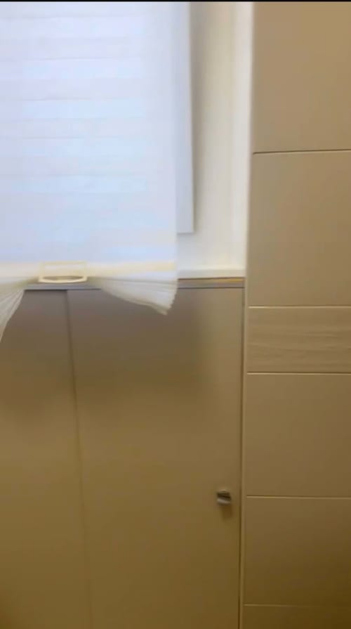 Modernes Apartment-Interieur in Magnolia Apartments Mailand mit beigen Wänden, offener Tür und Stadtblick