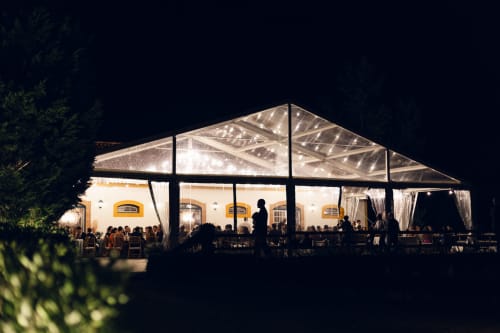 Evento noturno na tenda da Quinta da Alcaidaria-Mór com hóspedes jantando, estrutura iluminada em Ourém-Fátima, Portugal