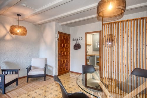 Lounge moderne aux Finques Garcia Enrich, Palafrugell avec mobilier en bois, luminaires suspendus tissés et carrelage
