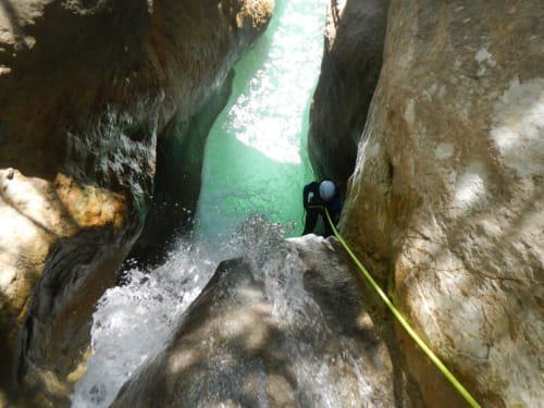 Un canyonéiste en rappel dans une gorge étroite aux eaux émeraude près d'El Pont de Suert