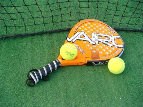 Raquette de tennis Orange Viper avec balles Wilson sur court vert à l'Hôtel Flor de Neu