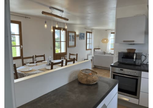Cuisine moderne et coin repas du gîte Locmaria Belle Île en Mer avec îlot central, électroménagers inox et