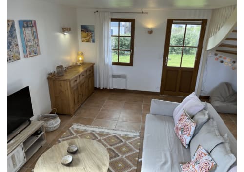 Séjour lumineux avec vue sur le jardin, mobilier en bois, confortable et TV à Locmaria, Belle Île en Mer