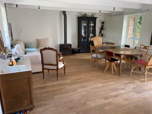 Séjour ouvert avec table à manger, salon, poêle à bois et vue sur jardin à Locmaria Belle Île en Mer