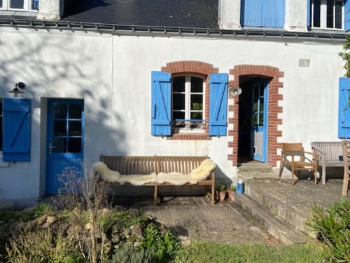Charmant cottage à Loc'Maria Belle Île avec volets bleus, jardin aménagé et fenêtres à cadre brique dominant la