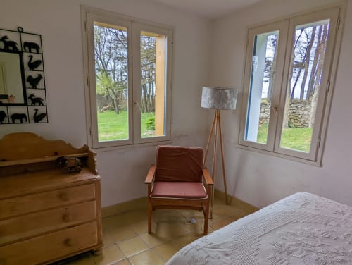Chambre lumineuse au mobilier en bois, vue mer par portes-fenêtres et paysage rural à Locmaria, Belle Île