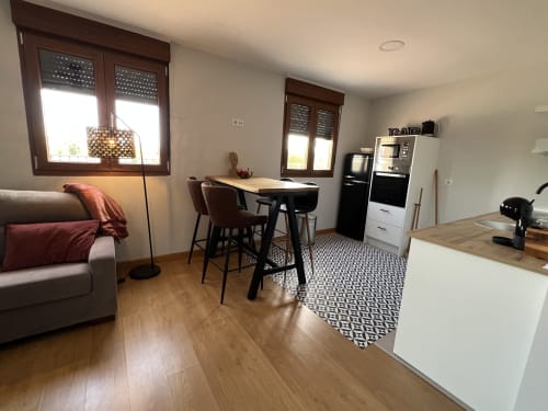 Cocina y sala de estar modernas en apartamento de Salamanca con mesa de comedor, suelos de madera y vistas a monumentos