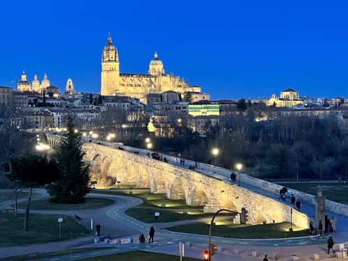Catedral de Salamanca y puente romano iluminados al atardecer, vista desde los apartamentos AlmaMaterSalamanca