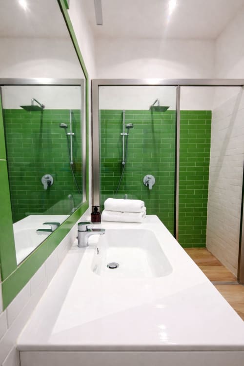 Bagno moderno con piastrelle verde menta, doppio lavabo e doccia walk-in presso l'hotel apartment Zoelia a Roma