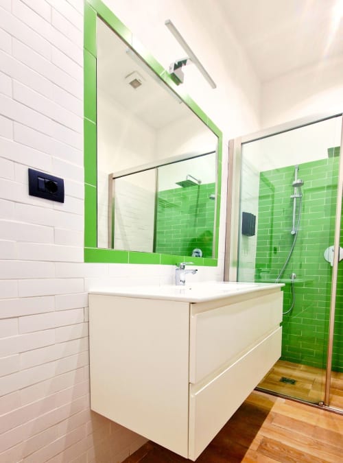 Bagno moderno a Zoelia Roma con doccia in piastrelle verdi, lavabo bianco e specchio nell'appartamento Vaticano