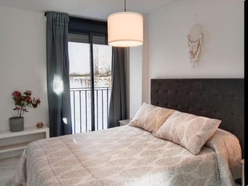 Habitación moderna en Top Home Integra, Jerez de la Frontera, con balcón con vistas a la ciudad y mobiliario contemporáneo