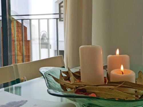 Velas y hojas secas sobre mesa en apartamento Top Home Integra, Jerez de la Frontera con vistas a la ciudad
