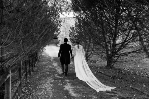 Noivos caminhando em sendeiro arborizado na Quinta da Alcaidaria-Mór, espaço de casamento em Fátima