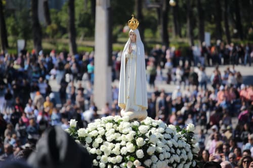White floral arrangement with religious statue at Fátima sanctuary, Ourém, Portugal pilgrimage site