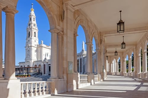 Elegant colonnade with white columns overlooking Sanctuary of Fátima basilica, Quinta da Alcaidaria-Mór BnB, Portugal