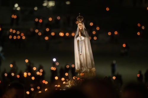 Religious statue with crown and veil illuminated by bokeh lights at Quinta da Alcaidaria-Mór, Fátima