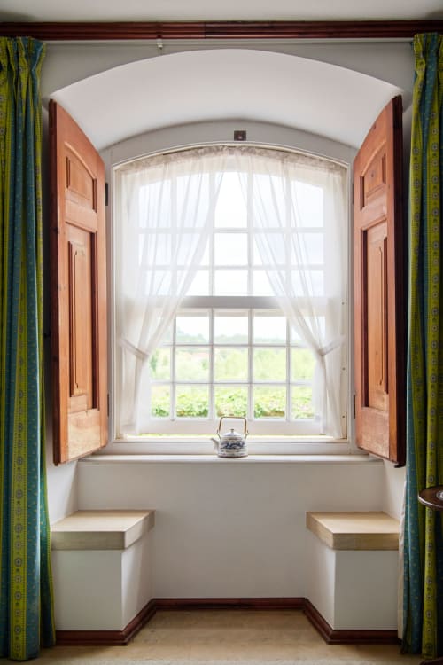 Arched window alcove with wooden shutters at Quinta da Alcaidaria-Mór boutique hotel in Ourém-Fátima, Portugal