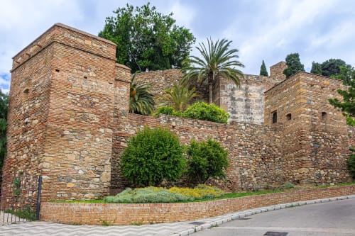 Muros de fortaleza histórica de piedra con torres en Málaga, España, cerca de Ab Be Apartments