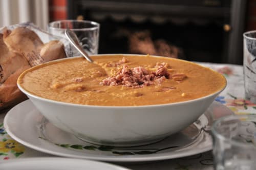 Cremosa sopa con guarnición de jamón servida en Ab Be Apartments, Málaga, España