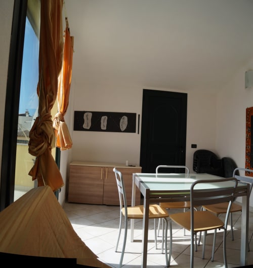 Dining area in Sa Domo de Su Zeniu apartment, Orosei with table, chairs, wooden cabinet and veranda view