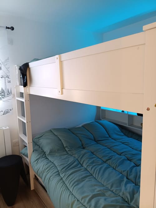 Lit superposé avec literie bleue dans une chambre lumineuse du Gîte des Gônes, appartement à Feyzin