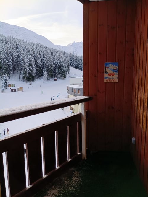 Vue enneigée de la vallée montagnarde depuis le balcon en bois du Gîte des Gônes, station alpine de Feyzin